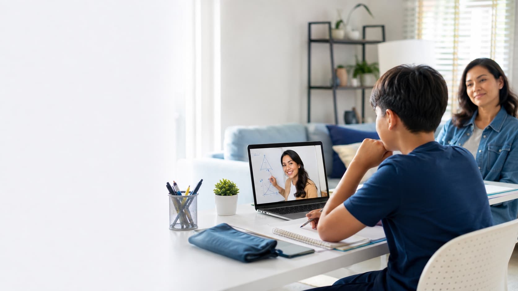A student in a live online tutoring session at home while a parent looks on
